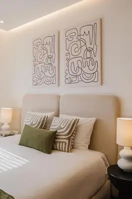 a bedroom with a bed with two pictures on the wall at Sejour lumineux et moderne dans le centre de Marrakech in Marrakech