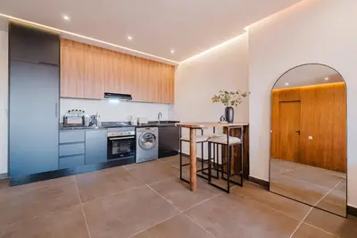 a kitchen with a wooden table and a counter at Sejour lumineux et moderne dans le centre de Marrakech in Marrakech