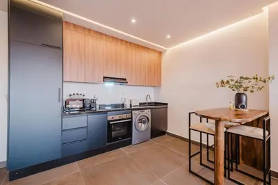 a kitchen with a table and a washer and dryer at Sejour lumineux et moderne dans le centre de Marrakech in Marrakech