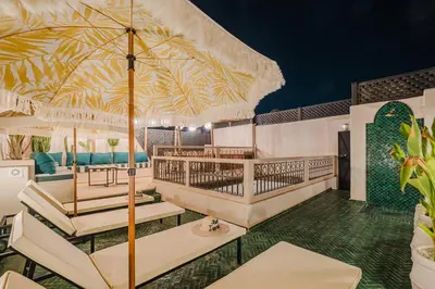 a resort with a large patio with tables and chairs at Riad Imrani - piscine - 6 mn from Jamaa Al Fna in Marrakech