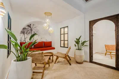 a living room with a red couch and a mirror at Riad Imrani - piscine - 6 mn from Jamaa Al Fna in Marrakech