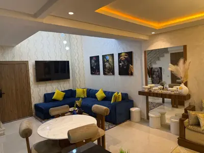 a living room with a blue couch and a table at Duplex chic et lumineux avec piscine proche centre in Marrakech