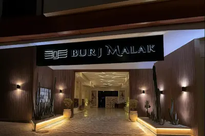 a building with a sign for a buy mall at Duplex chic et lumineux avec piscine proche centre in Marrakech