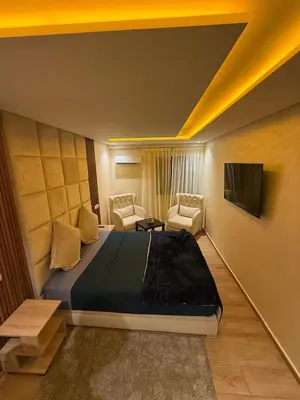 a bedroom with a bed and a tv on a wall at Duplex chic et lumineux avec piscine proche centre in Marrakech