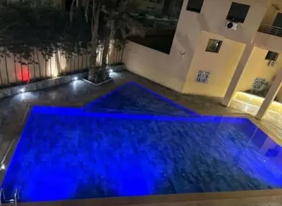 a swimming pool with blue lighting in a building at Duplex chic et lumineux avec piscine proche centre in Marrakech