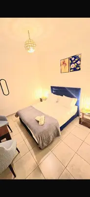 a bedroom with a bed and a chandelier at Appartement a 5 min de l aeroport de marrakech in Marrakech