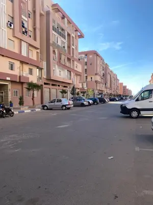 a parking lot with cars parked in front of buildings at Appartement a 5 min de l aeroport de marrakech in Marrakech