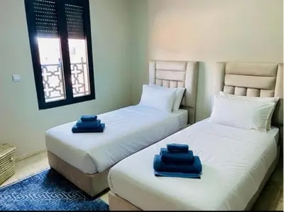 two beds sitting next to each other in a room at Villa Dar Ouladi - Marrakech - Pool & Rooftop in Marrakech