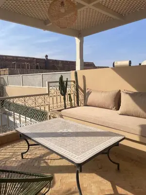a patio with a couch and a table on a balcony at Riad 4 chambres, Piscine, Pdj inclus in Marrakech