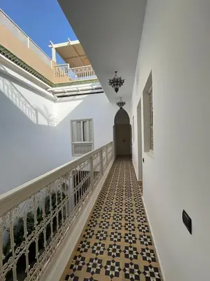 a hallway of a white building with a tile floor at Riad 4 chambres, Piscine, Pdj inclus in Marrakech