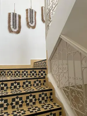 a staircase with black and white tiled floors and a stair case at Riad 4 chambres, Piscine, Pdj inclus in Marrakech