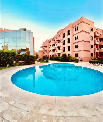 a large blue swimming pool in front of a building at Lilia apartment marrakech in Marrakech