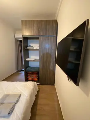 a bedroom with a closet and a bed and a tv at Appartement 1 chambre à Gueliz Confort et piscine in Marrakech