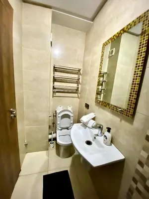 a bathroom with a sink and a toilet and a mirror at Appartement 1 chambre à Gueliz Confort et piscine in Marrakech
