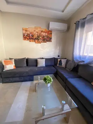a living room with a blue couch and a table at Appartement 1 chambre à Gueliz Confort et piscine in Marrakech