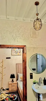 a bathroom with a sink and a mirror and a bed at Red Studio Marrakech in Marrakech
