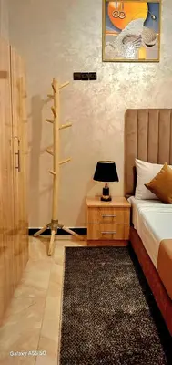 a bedroom with a bed and a tree on the wall at Red Studio Marrakech in Marrakech