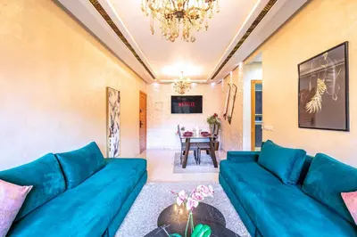 a living room with a blue couch and a table at Emeraude - Confort et parking privé in Marrakech