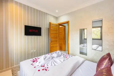 a bedroom with a white bed with flowers on it at Emeraude - Confort et parking privé in Marrakech