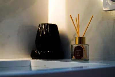 a bottle of perfume sitting on a counter with sticks in it at Villa Lily in Tameslouht