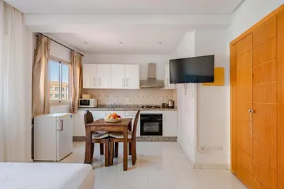 a kitchen with a table and a kitchen with a television at Propre et bien situé avec parking sous-sol etWi-Fi in Marrakech
