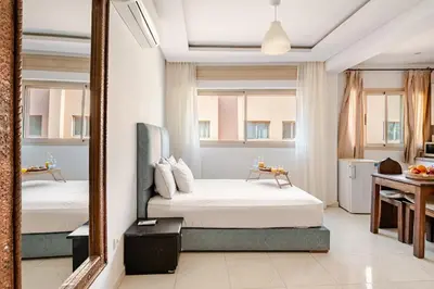 a bedroom with two beds and a mirror at Propre et bien situé avec parking sous-sol etWi-Fi in Marrakech