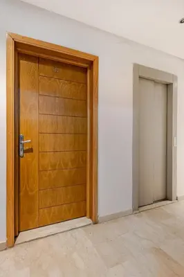 a wooden door in a room with a doorway at Propre et bien situé avec parking sous-sol etWi-Fi in Marrakech