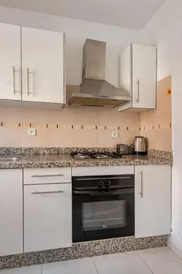 a kitchen with white cabinets and a stove top oven at Propre et bien situé avec parking sous-sol etWi-Fi in Marrakech