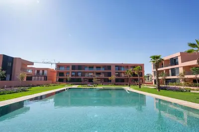 a large swimming pool in front of a building at Appartement moderne et spacieux avec terrasse et piscine au Noria Golf in Marrakech