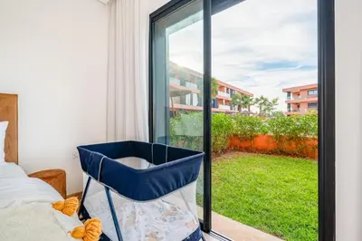 a blue chair sitting in front of a window at Appartement moderne et spacieux avec terrasse et piscine au Noria Golf in Marrakech