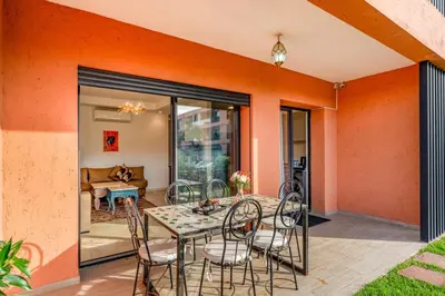 a dining room with a table and chairs at Appartement moderne et spacieux avec terrasse et piscine au Noria Golf in Marrakech