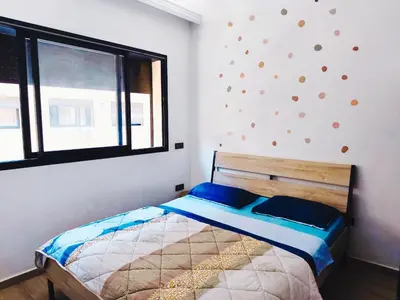 a bedroom with a bed and a window at Cocoon Apartment & Pool ctm aeropot train station in Marrakech