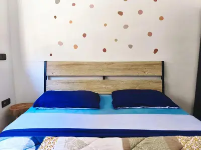 a bedroom with a bed with blue sheets and a headboard at Cocoon Apartment & Pool ctm aeropot train station in Marrakech