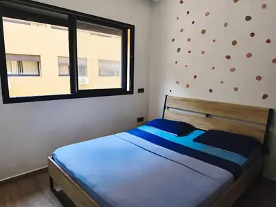 a bedroom with a large bed with a window at Cocoon Apartment & Pool ctm aeropot train station in Marrakech