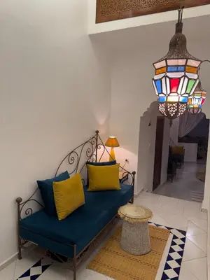 a living room with a blue couch and a chandelier at Riad LK25 in Marrakech