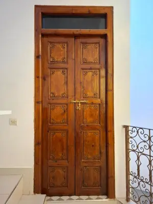 a wooden door in a room with a staircase at Riad LK25 in Marrakech