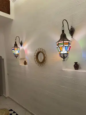 two lights hanging on a wall with a mirror at Riad LK25 in Marrakech