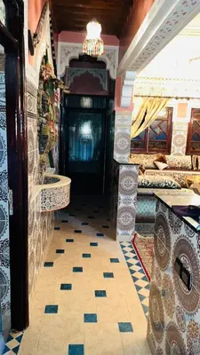 a room with a fireplace and a tiled floor at Appartement in Marrakech
