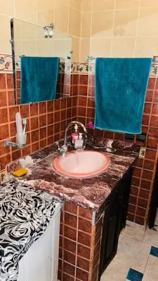 a bathroom with a sink and blue towels at Appartement in Marrakech