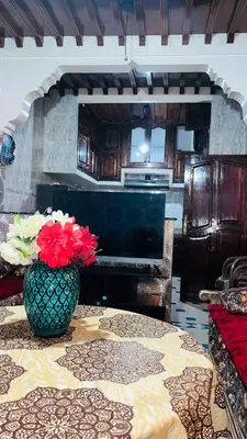 a room with a table with a vase of flowers on it at Appartement in Marrakech