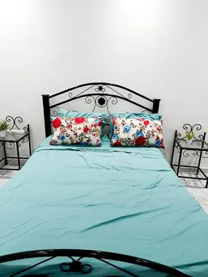 a bedroom with a bed with blue sheets and pillows at Stylish Moroccan Apartment in Marrakech