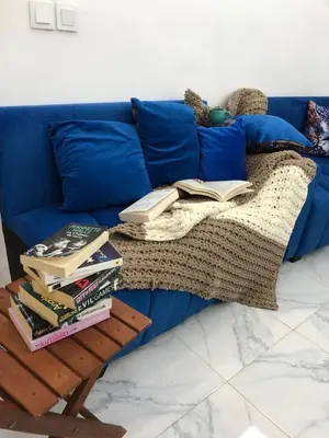 a blue couch with books on a coffee table at Stylish Moroccan Apartment in Marrakech