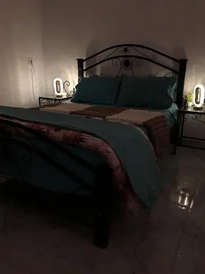 a bedroom with a large bed with green sheets and pillows at Stylish Moroccan Apartment in Marrakech