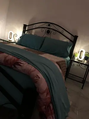 a bedroom with a bed with green sheets and pillows at Stylish Moroccan Apartment in Marrakech