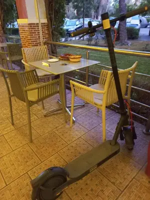 a moped parked next to a table and chairs at Breeze home in Marrakech