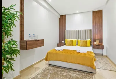 a bedroom with a bed with yellow sheets and yellow pillows at Charmant appartement avec terrasse au cœur de Marrakech in Marrakech