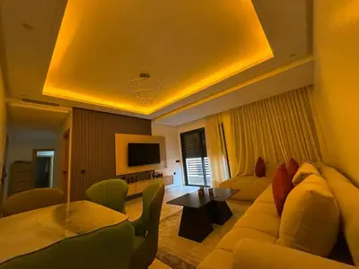 a living room with a couch and a tv at Atlas Light Heart of Gueliz & Parking in Marrakech