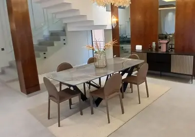 a dining room table with chairs and a staircase at Villa Soleil Couchant in Marrakech