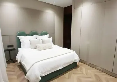 a bedroom with a large white bed with a green headboard at Villa Soleil Couchant in Marrakech