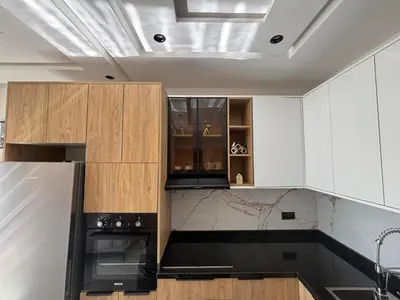 a kitchen with white cabinets and black appliances at Appartement Original et unique en plein hivernage pour familles in Marrakech